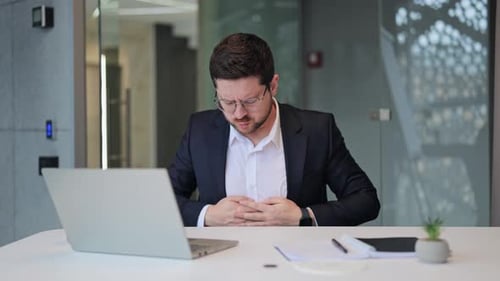 Businessman Suffering Acute Stomach Pain in Modern Office Environment