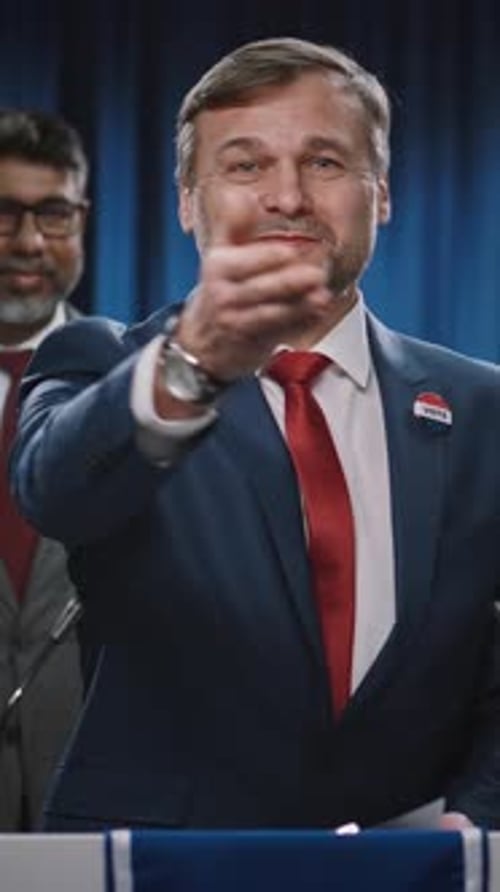 Man Speaking at Podium Gives a Handshake and Wave