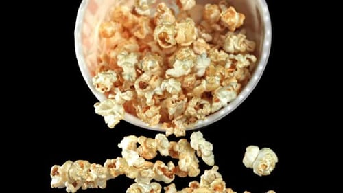 Popcorn Falling from Striped Container on Black Background