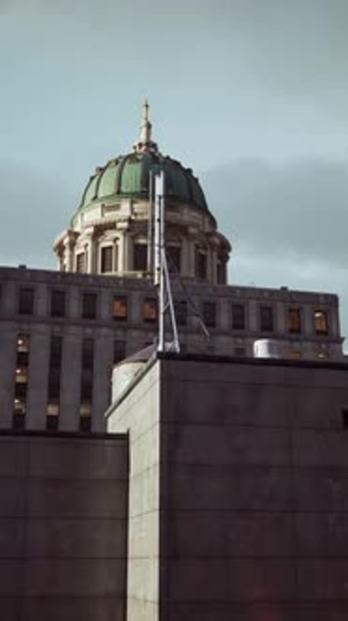 A Tall Building with a Green Dome on Top