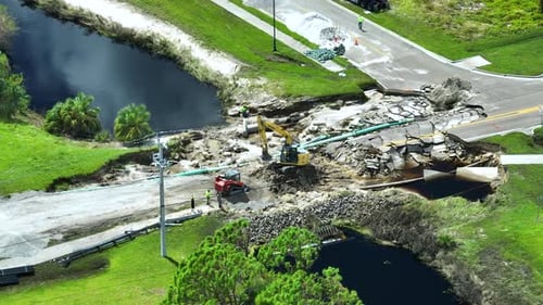 Luftaufnahme der Rekonstruktion einer beschädigten Straßenbrücke, die vom Fluss zerstört wurde, nachdem das Hochwasser gespült wurde