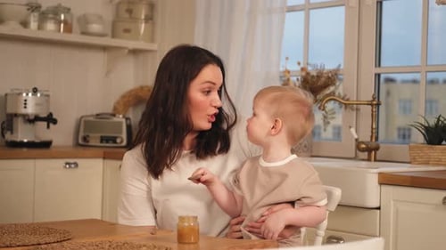 Mother Feeding Toddler at Kitchen Table