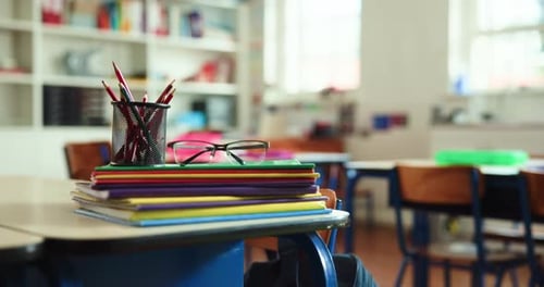 School desk with supplies in empty classroom