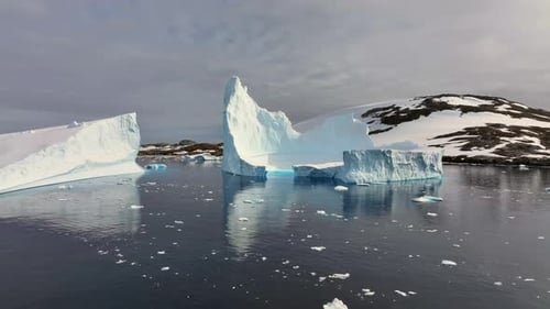 Glaciar majestoso flutuando na costa da Antártica ao pôr do sol, vista aérea