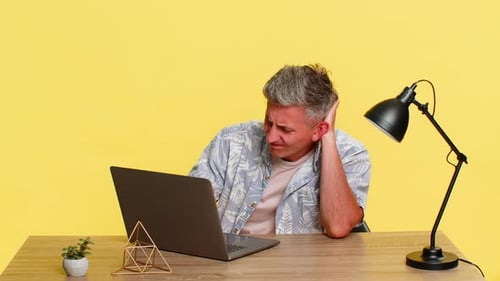 Adult Man Holding Head in Frustration While Looking at Laptop After Mistake Computer Virus Problem