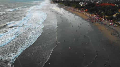 Beautiful Seminyak and Double Six Beach drone footage in Bali with cinematic waves many crowded peop