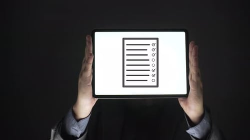 Tablet Displaying Animated Checklist Against Dark Background