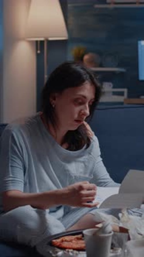 Vertical Video Annoyed Desperate Young Woman Sitting on Sofa Reading Eviction Notice
