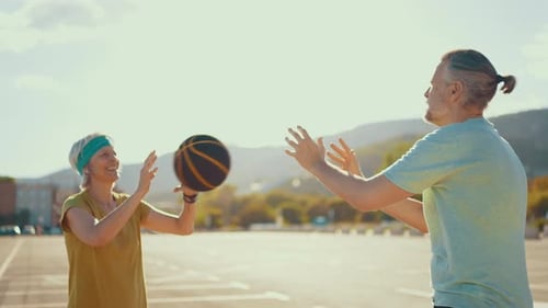 Active Couple Playing Basketball by the Beach