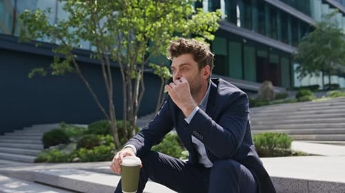 Relaxed Employee Eating Sandwich Sitting Street Stairs with Beverage Takeaway