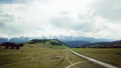 Road Near Snowcapped Mountain Peaks