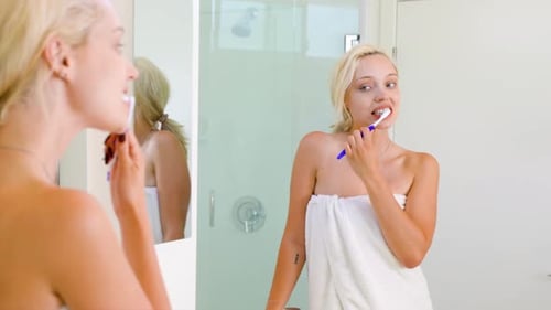 Woman Brushing Teeth in Bright Bathroom