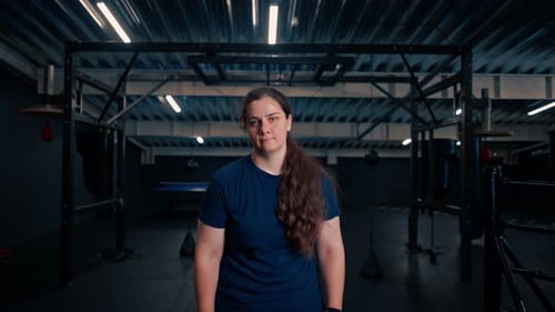 portrait of tired strong serious girl boxer trainer in gym after fight or training sport concept