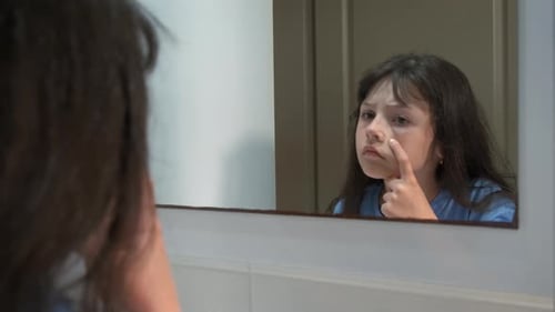 Das kleine Mädchen ist unzufrieden mit ihrem Gesicht