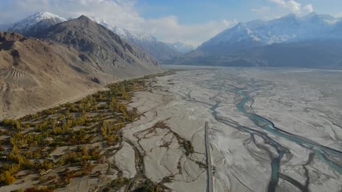 Aerial view of snow-capped mountains and winding river, Pakistan.