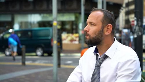 Young Businessman Eating Tasty Croissant and Drinking Coffee in the City 30s