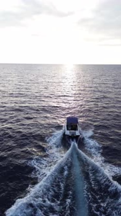 Boot segelt in den Sonnenuntergang auf offenen Meeresgewässern
