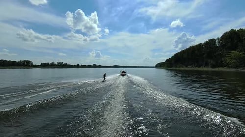 Wakesurfer-Training, Wakeboard-Fähigkeiten hinter dem Boot, die Flusswellen hinunter, Luftbild.