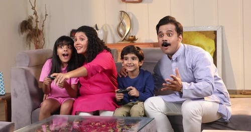 Excited Family Playing Video Games Together in Living Room