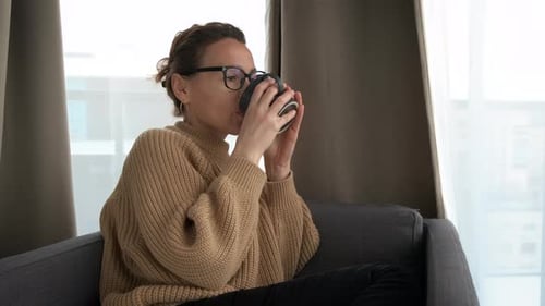 Woman with Glasses Relaxing with a Hot Drink