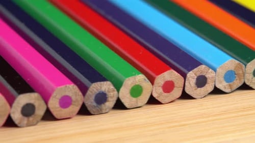 Colorful Pencils Lined Up on Wooden Surface