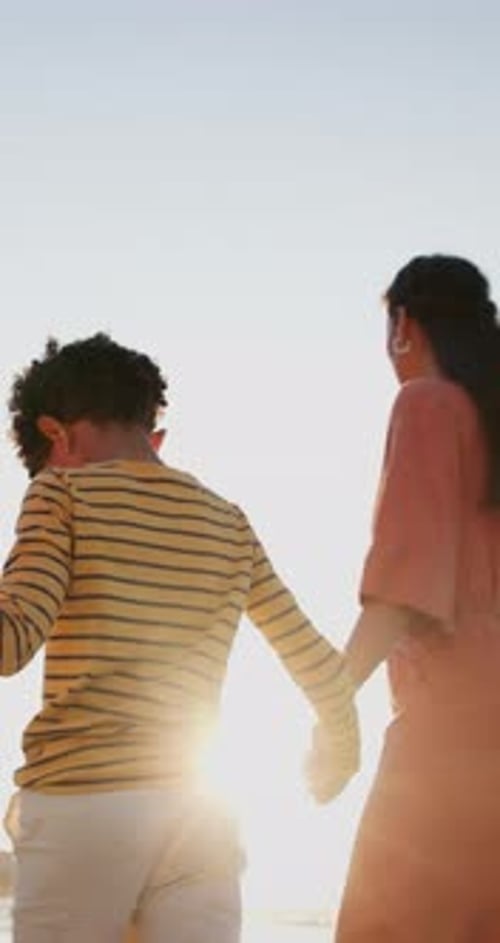 Family, parents and kid walking on beach for summer holiday, vacation and outdoor wellness in lens