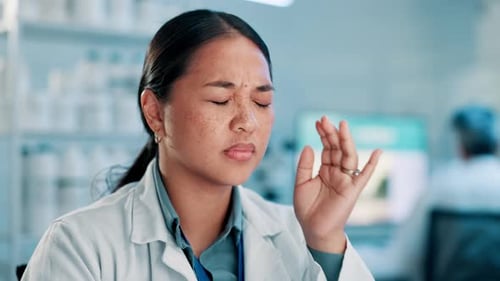 Woman in Lab Coat Massaging Temples With Headache
