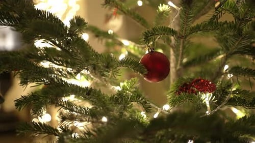 Christmas tree with glowing fairy lights and red ornaments