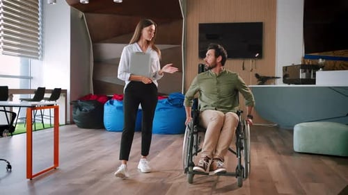 Woman Walking with Man in Wheelchair at Office