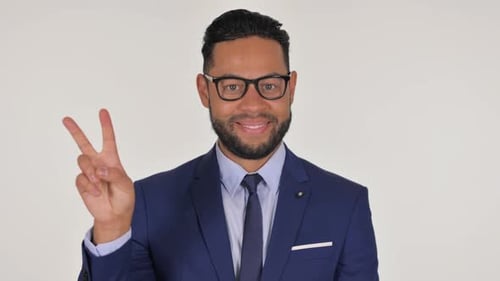 Man in Suit Smiles Holding Up Peace Sign