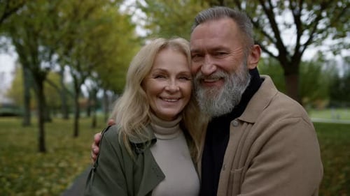 Smiling Couple Embracing in Park on Autumn Day