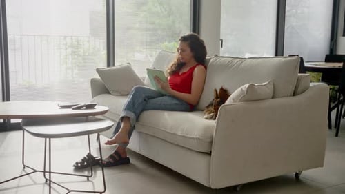 Woman Relaxing on Couch at Home with Dog