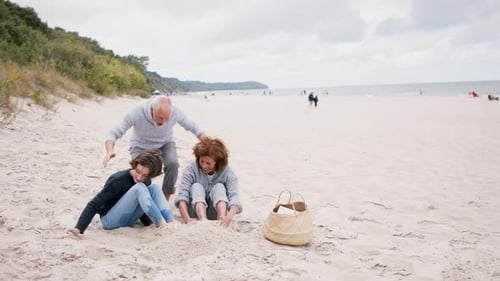 Abuelos felices construyen un castillo de arena con su nieta en unas soleadas vacaciones en la playa
