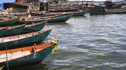 Southeast Asian fisherman's colorful aqua and orange boats, flowers tied to the bow, bobbing up and