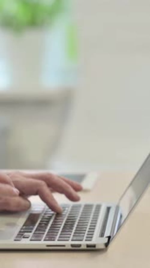 Side View of Male Hands Typing on Laptop, vertical video