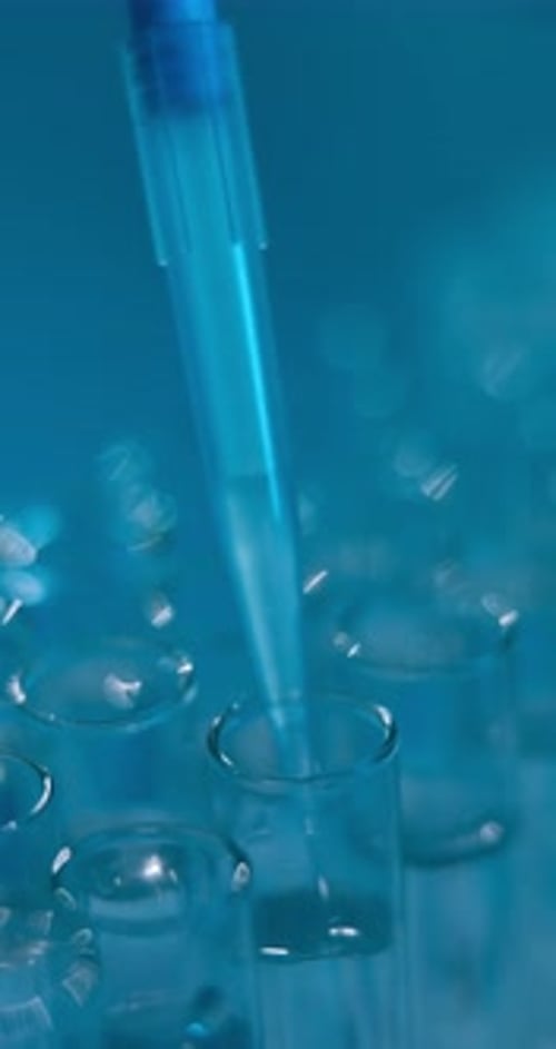 Close Up of Pipette Dripping Liquid Into Test Tube