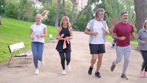 Group of Senior Friends Running Together in a Park