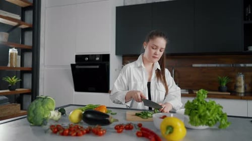 Woman Dancing and Slicing Vegetables in Modern Kitchen