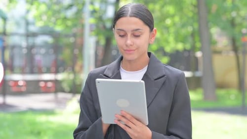 Young Adult Using Tablet in Urban Park Setting