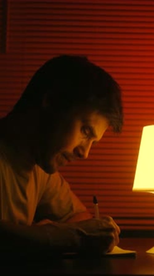 Focused Man Writing a Letter at Night By Lamplight