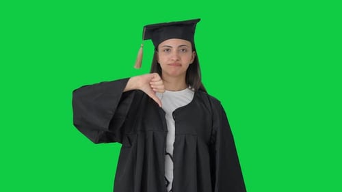 Disappointed Indian college graduate girl showing thumbs down sign Green screen