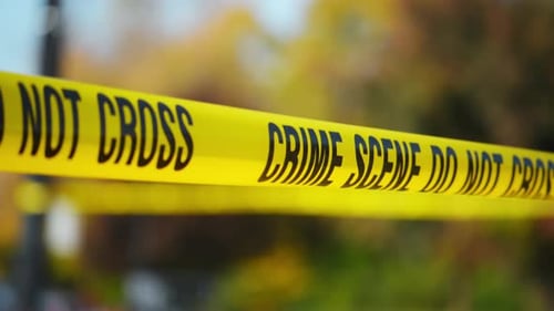 The Bright Yellow Crime Scene Do Not Cross Tape Stretched Across an Urban Place Marking a Restricted