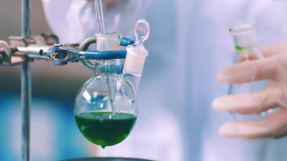 Medical staff use Suction Pipette dispensing green liquid to a tissue ...