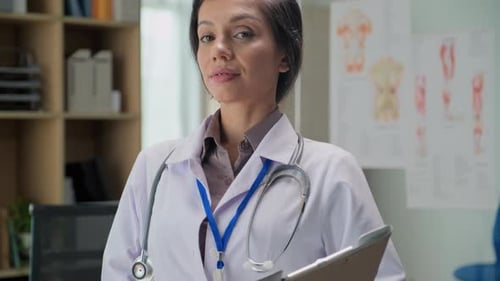 Smiling Female Doctor in Office with Stethoscope and Clipboard