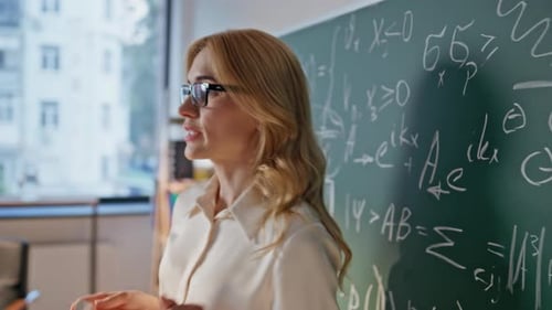 Algebra Educator Writing Chalkboard Explaining Formulas in School Class Closeup