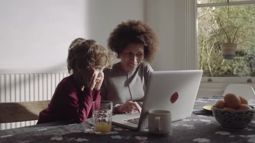Woman and child looking at a laptop computer indoors
