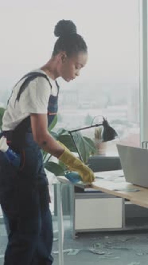 Concentrated Female Maintenance Worker Quickly Cleans and Organizes Office Area Using Precise and
