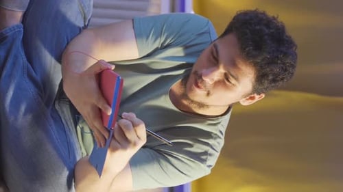 Young Adult Writing in Notebook with Pen