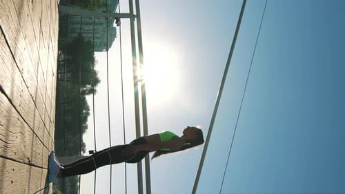 Woman Does Bridge Exercise on Urban Bridge