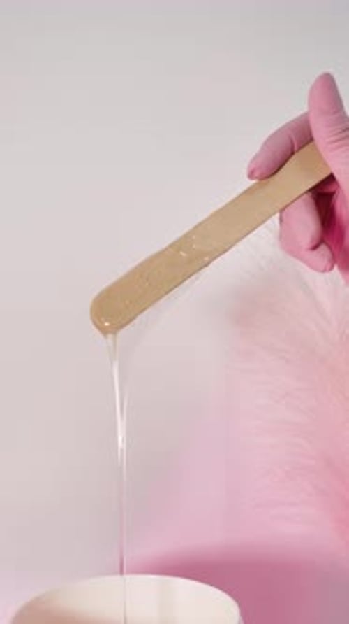 Wax Dripping from Wooden Stick for Hair Removal